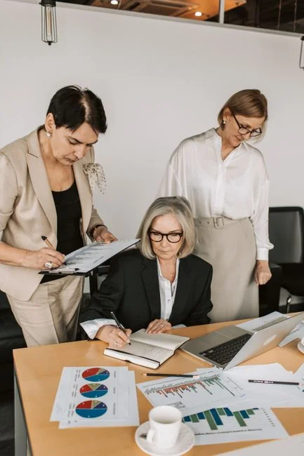 Des mains échangent sur une stratégie marketing autour de graphiques, dans un bureau.